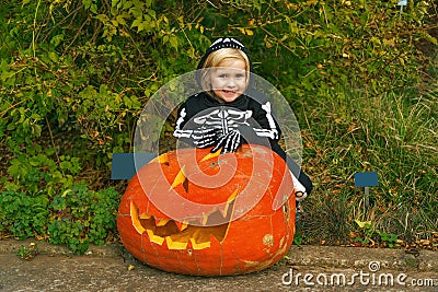 Happy child with huge Halloween pumpkin Jack Oâ€™Lantern Stock Photo